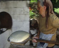 a still from 24 Hours in the Village : A local woman making bread