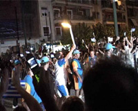 Crowds in Dionysis Areopagitou St, watching the Olympic flame procession passing through